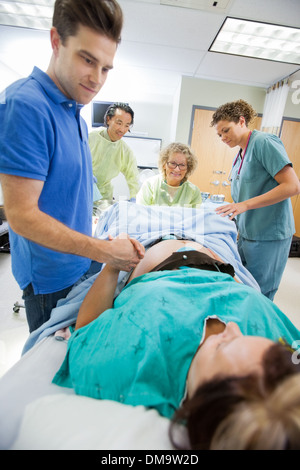 Cura Uomo Donna tenendo la mano durante la consegna in ospedale Foto Stock