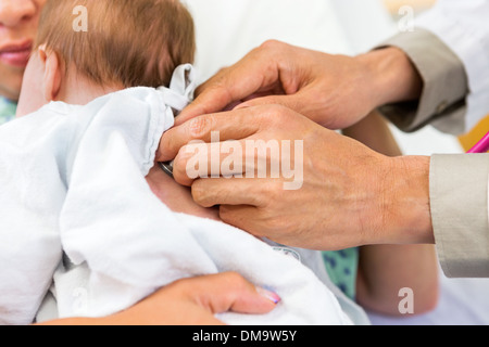 Medico esaminando le mani Babygirl neonato con uno stetoscopio Foto Stock