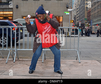 Un esercito della salvezza volontario cantare, ballare e suonare le campane durante la raccolta in Midtown Manhattan, a New York City Foto Stock