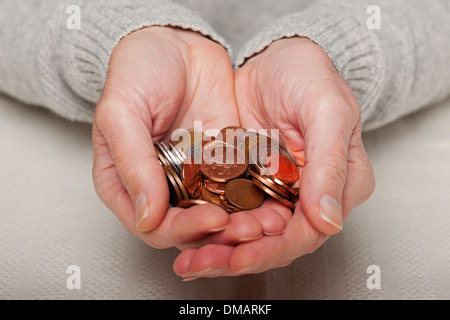 Primo piano di uomo persona mani in possesso inglese costo di vita pagamento denaro piccolo cambio moneta monete Inghilterra Regno Unito GB Gran Bretagna Foto Stock