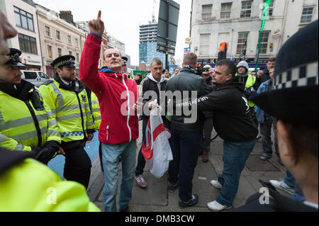 Brick Lane, Londra, Regno Unito. 13 dicembre, 2013. Gruppo musulmano "Sharia" Progetto mirato i negozi per la vendita di alcol e festaioli di Brick Lane. Il gruppo guidato da predicatore islamista, Anjem Choudary, è entrato in contatto con un gruppo di "Patrioti" e a destra dell' affiliato attivisti che hanno espresso il loro parere. Credito: Lee Thomas/Alamy Live News Foto Stock