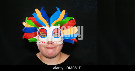 Ragazza in una maschera di Arlecchino con un divertente guardare sul suo viso. Foto Stock