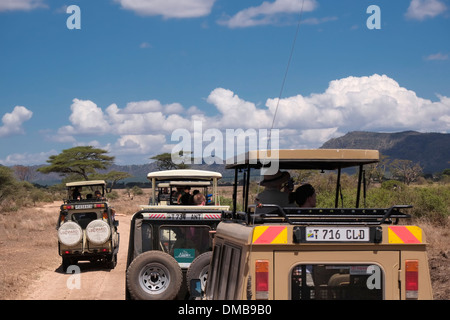 I turisti in sommità aperta Jeep Safari presso il Parco Nazionale del Serengeti un Sito Patrimonio Mondiale dell'UNESCO in Tanzania Africa orientale Foto Stock