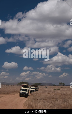 I turisti in sommità aperta Jeep Safari presso il Parco Nazionale del Serengeti un Sito Patrimonio Mondiale dell'UNESCO in Tanzania Africa orientale Foto Stock