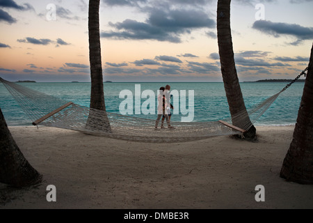 Aitutaki. Isole Cook. Polinesia. Oceano Pacifico del sud. Due turisti a piedi lungo la spiaggia dell'Hotel Aitutaki Lagoon Resort Foto Stock