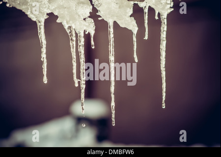 Inverno ghiaccioli che pendono dal tetto sfondo stagionali colori alla moda Foto Stock