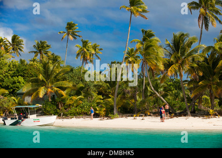 Aitutaki. Isole Cook. Polinesia. Oceano Pacifico del sud. Un turista passeggiate lungo il bordo della spiaggia orlata di palme in un piede Foto Stock