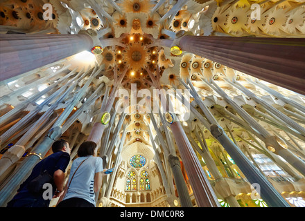 Giovane ammirando il soffitto del Tempio della Sagrada Familia di Antoni Gaudi. Barcellona, Spagna. Foto Stock