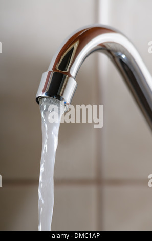 L'immagine verticale di un rubinetto con acqua che scorre normalmente Foto Stock