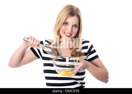 Giovane donna uova di miscelazione Foto Stock