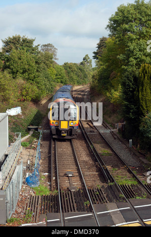 Il treno attraversa il livello crossing presso la stazione ferroviaria di Farnham, Surrey, Inghilterra, Regno Unito. Foto Stock