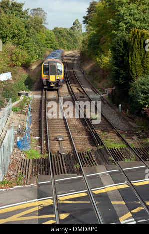 Il treno attraversa il livello crossing presso la stazione ferroviaria di Farnham, Surrey, Inghilterra, Regno Unito. Foto Stock