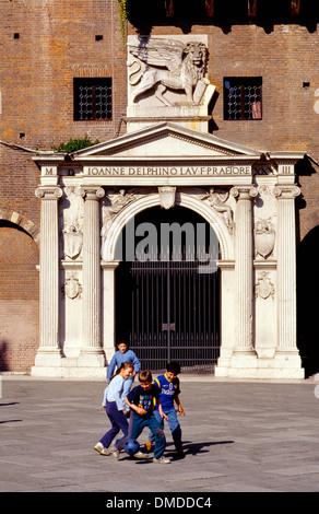 Ragazzi che giocano a calcio in parte anteriore del Sanmicheli porta del Palazzo del Podestà, Piazza dei Signori, Verona, Italia Foto Stock