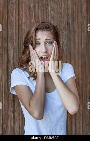 Oh, il mio Gosh! - Orientamento verticale in prossimità di una bella ragazza adolescente con le mani sul suo viso e cercare di incredulità Foto Stock