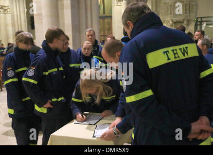 Magdeburg, Germania. Xiv Dic, 2013. Mmembers del THW firmare un libro di condoglianze a un servizio di lutto per le vittime di un incidente in barca presso la Cattedrale di Magdeburgo, Germania, 14 dicembre 2013. Il servizio di lutto per due elementi femmina dell'Agenzia federale per il rilievo tecnico (THW) ha visto la partecipazione di oltre 800 persone. Una barca capovolta sull'Elba il 23 novembre 2013. Due giovani donne sono state scattate in ospedale e vi morì poco dopo. Foto: Jens WOLF/dpa/Alamy Live News Foto Stock