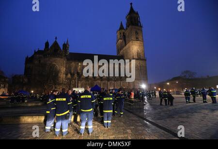 Magdeburg, Germania. Xiv Dic, 2013. Membri della THW stand davanti alla cattedrale un servizio di lutto per le vittime di un incidente in barca a Magdeburgo, Germania, 14 dicembre 2013. Il servizio di lutto per due elementi femmina dell'Agenzia federale per il rilievo tecnico (THW) ha visto la partecipazione di oltre 800 persone. Una barca capovolta sull'Elba il 23 novembre 2013. Due giovani donne sono state scattate in ospedale e vi morì poco dopo. Foto: Jens WOLF/dpa/Alamy Live News Foto Stock