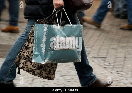 Un pedone cammina con una borsa da shopping attraverso il Koenigsstrasse a Stoccarda, Germania, 14 dicembre 2013. Ogni anno di masse di persone visitano il Koenigsstrasse al negozio per il Natale. Foto: Thomas Niedermueller/dpa Foto Stock