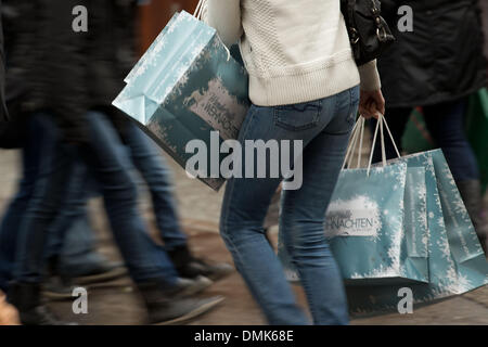 Un pedone cammina con una borsa da shopping attraverso il Koenigsstrasse a Stoccarda, Germania, 14 dicembre 2013. Ogni anno di masse di persone visitano il Koenigsstrasse al negozio per il Natale. Foto: Thomas Niedermueller/dpa Foto Stock