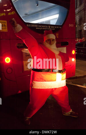 Londra, Regno Unito. 14 dicembre 2013 centinaia di buontemponi dell annuale Santa con evento, riuniti fuori BBC Broadcasting House in Portland Place. Hanno cantato e ballato alla musica mobile giocatori diffondendo la loro allegria natalizia per i passanti. I funzionari di polizia sono arrivati a garantire la strada era chiaro. Credito: Nelson pereira/Alamy Live News Foto Stock