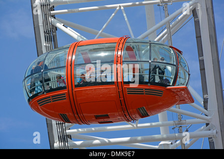 Primo piano dei passeggeri in una capsula sulla ruota panoramica del London Eye decorata con la combinazione di colori Vermillion della EDF Energy Foto Stock