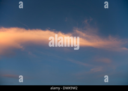 Wispy formazioni di nubi cattura i colori del sole al tramonto. Foto Stock