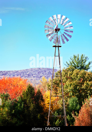 Mulino a vento tra belle foglie di autunno Foto Stock