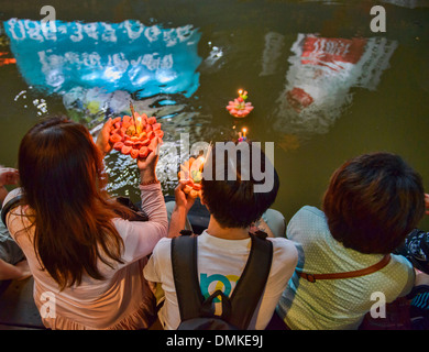 Gli amici si riuniscono per rilasciare le offerte di flottante durante Loy Kratong festival a Bangkok, in Thailandia Foto Stock