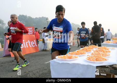 New Delhi, India. 15 Dic, 2013. Un uomo preleva arancione durante la Delhi Mezza Maratona presso la storica Rajpath a Nuova Delhi, India, 15 dicembre 2013. Credito: Partha Sarkar/Xinhua/Alamy Live News Foto Stock