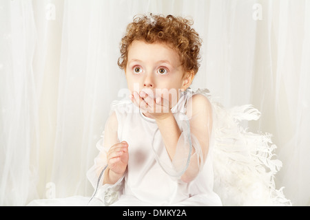 La foto qualitativa realizzata in un studio fotografico. Il ragazzino in un vestito di un angelo. Foto Stock