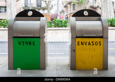 Cestini colorati sulla strada per il riciclaggio dei rifiuti con segni in catalano. Figueres, Spagna, Europa. Foto Stock