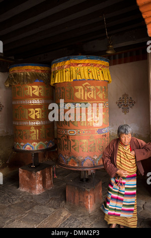 Il Bhutan, Bumthang Valley, Jambey Lhakang monastero, vecchio, donna la filatura ruote della preghiera Foto Stock