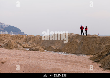 I supervisori che si affaccia su una spiaggia di progetto di bonifica del sito - Haeundae, Busan, Corea del Sud Foto Stock