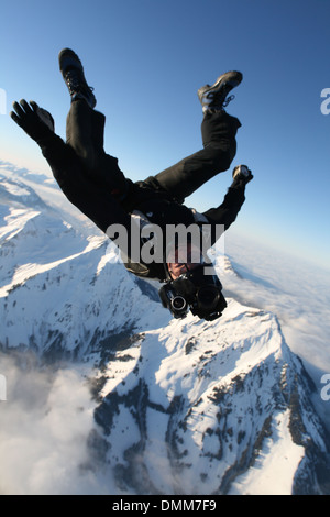 Paracadutista Freefly è volare su una neve spettacolare zona di montagna in una testa in posizione abbassata. In tal modo egli è catturare con la sua macchina fotografica. Foto Stock