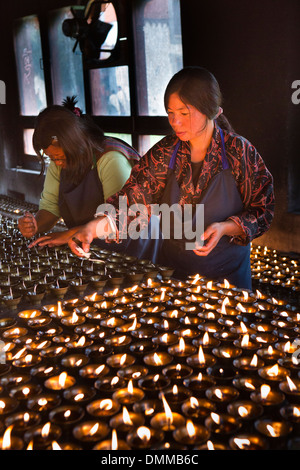 Il Bhutan, Bumthang Valley, Jambey Lhakang, monastero, donna illuminazione di lampade a burro Foto Stock