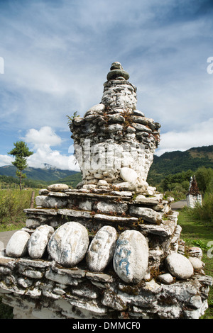 Il Bhutan, Bumthang Valley, Jambey antico in pietra dipinta di bianco chorten nel paesaggio rurale Foto Stock