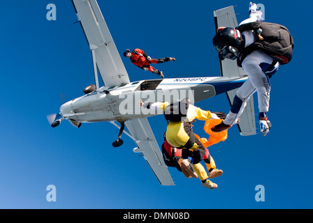 Skydiving Freefly team è saltato fuori da un aereo e rendere la formazione skydive il salto. Un ponticello ha la tenuta di un tubo dell'aria. Foto Stock