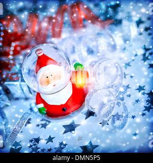 Blu sullo sfondo di Natale con graziosi snow globe Santa Claus su stelle, la magia della vigilia di Natale e durante le vacanze invernali Foto Stock