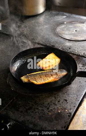Cucina di pesce in una padella Foto Stock