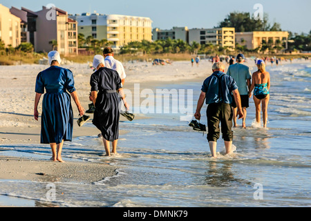 Amish godendo camminando lungo la spiaggia a Siesta Key, FL Foto Stock