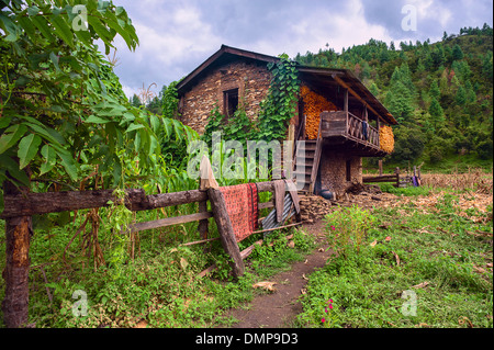 Un tradizionale in pietra a secco casa murata con essiccazione del mais al fresco, Sangti village, western Arunachal Pradesh, India. Foto Stock