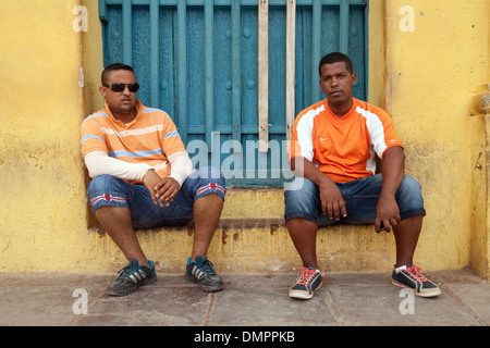 Due giovani uomini seduti in un portale, Trinidad, Cuba, Caraibi, America latina Foto Stock