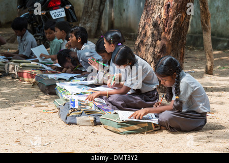 Rurale villaggio indiano la scuola dei bambini in una classe esterna facendo lavoro scolastico. Andhra Pradesh, India Foto Stock