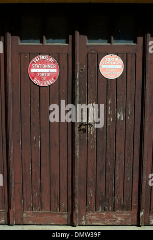 Sortie Vehicules Ne pas Stationner Merci, difesa De Stationner Sortie de Voitures segni sulle porte della Bastide città di Domme Foto Stock