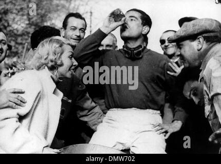 Aprile 12, 1955 - Pau, Francia - Racing driver Jean Behra prende un drink rinfrescante dopo aver vinto il Gran Premio gara di Pau, per celebrare con lui è sua moglie. (Credito Immagine: © Keystone Pictures USA/ZUMAPRESS.com) Foto Stock