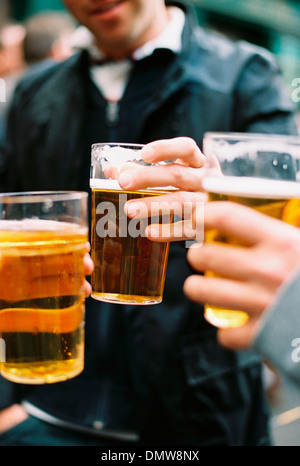 Tre persone a bere birra. La tostatura ogni o. Foto Stock