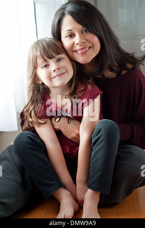 Una bella donna ispanica mantiene la sua bella figlia, sorridente. Un multirazziale madre e figlia ritratto di famiglia. Foto Stock