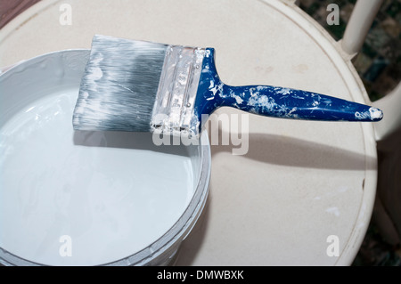 Spazzola di vernice su un aprire il barattolo di vernice in emulsione Foto Stock