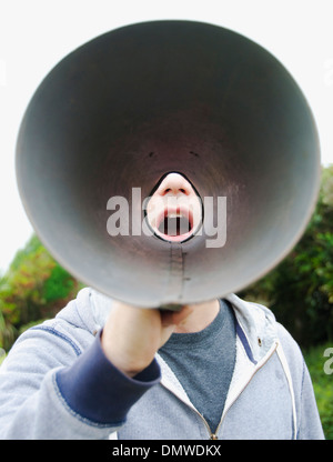 Un uomo con un megafono in aria aperta. Foto Stock