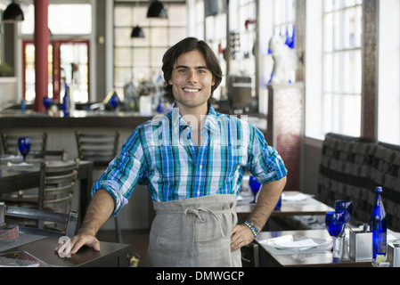 Un bar interno. Un cameriere in un controllato shirt. Foto Stock