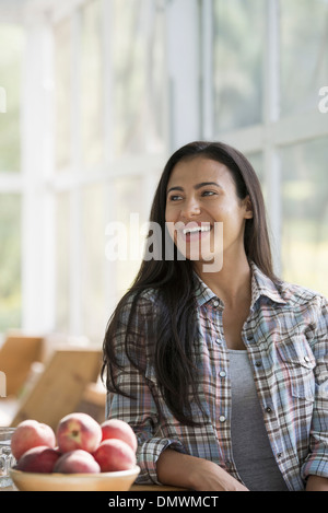 Un felice giovane donna seduta al tavolo. Foto Stock